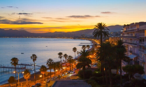 Cannes Coastline Sunset on the French Riviera Breathtaking sunset view over the Cannes coastline featuring palm-lined boulevards.Breathtaking sunset view over the Cannes coastline featuring palm-lined boulevards, Mediterranean waters and the glamorous French Riviera atmosphere.