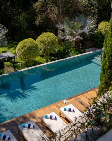 luxury-infinity-pool-sunbeds-cannes Elegant poolside cabana and luxury outdoor lounge area beside the swimming pool at Château Les Alouettes in Cannes.