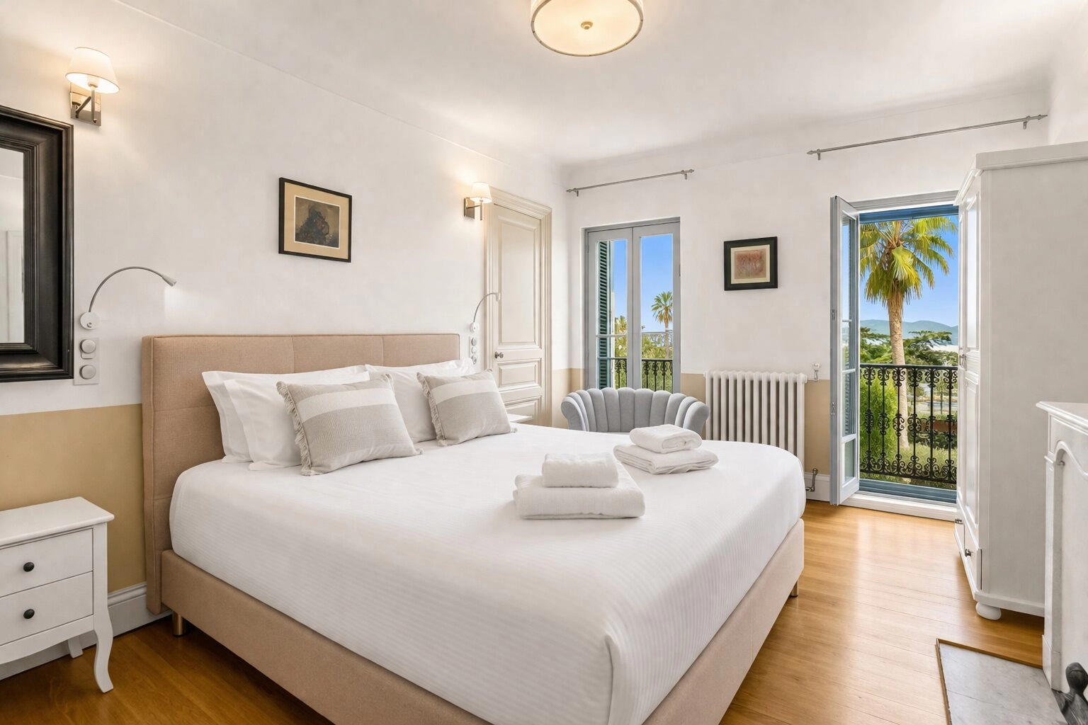 bright-luxury-bedroom-palm-view-cannes Elegant luxury bedroom with king-size bed, fireplace and French doors at Château Les Alouettes in Cannes.
