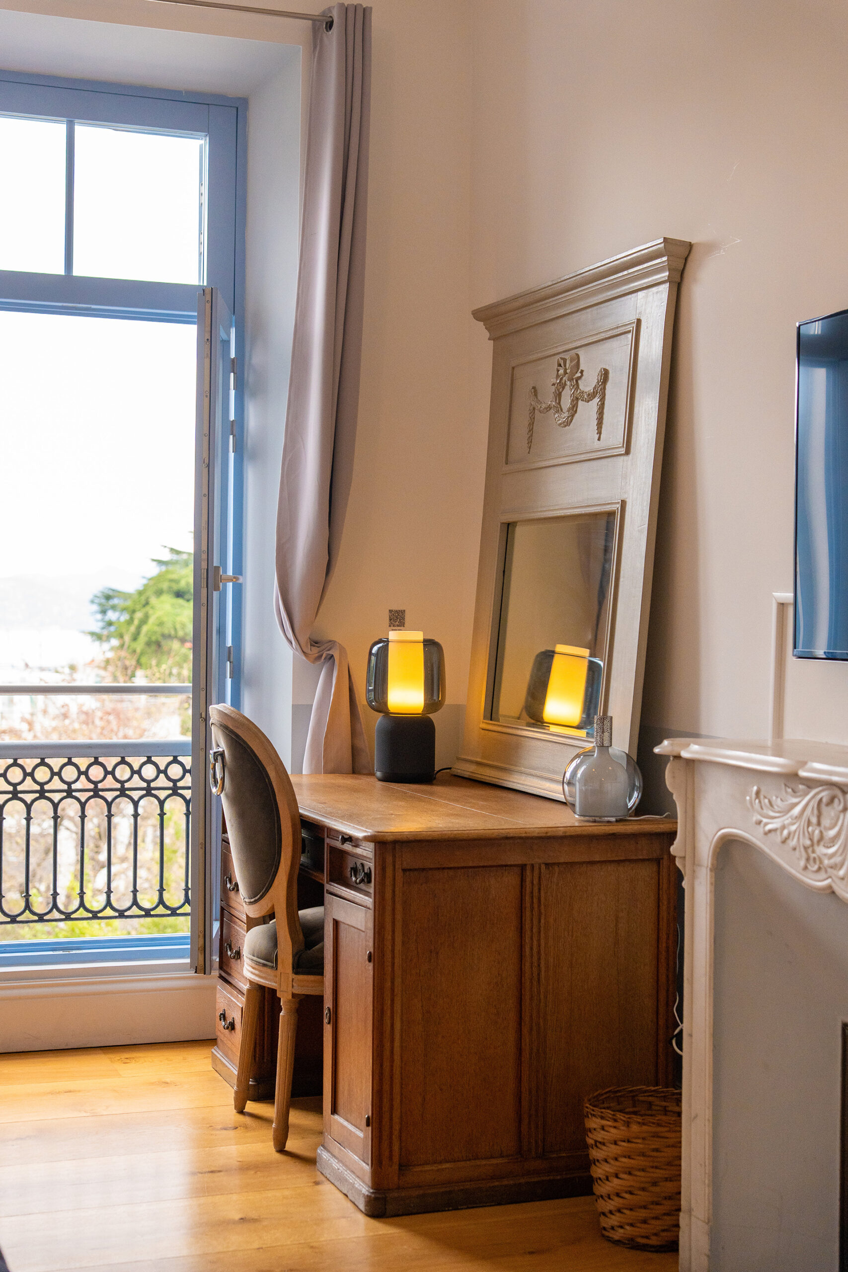 luxury-bedroom-desk-garden-view-cannes_result Elegant luxury bedroom with fireplace, soft neutral décor and French balcony doors at Château Les Alouettes Cannes.