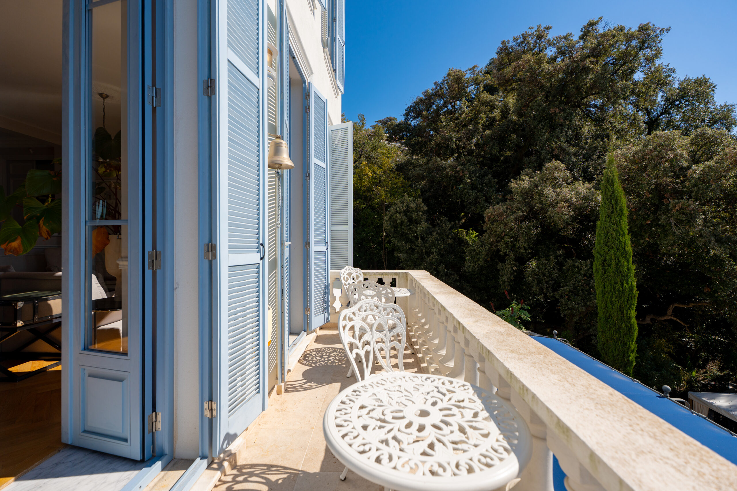 luxury-villa-balcony-glass-door-cannes Luxury lounge terrace with elegant outdoor seating and Mediterranean garden surroundings at Château Les Alouettes Cannes.